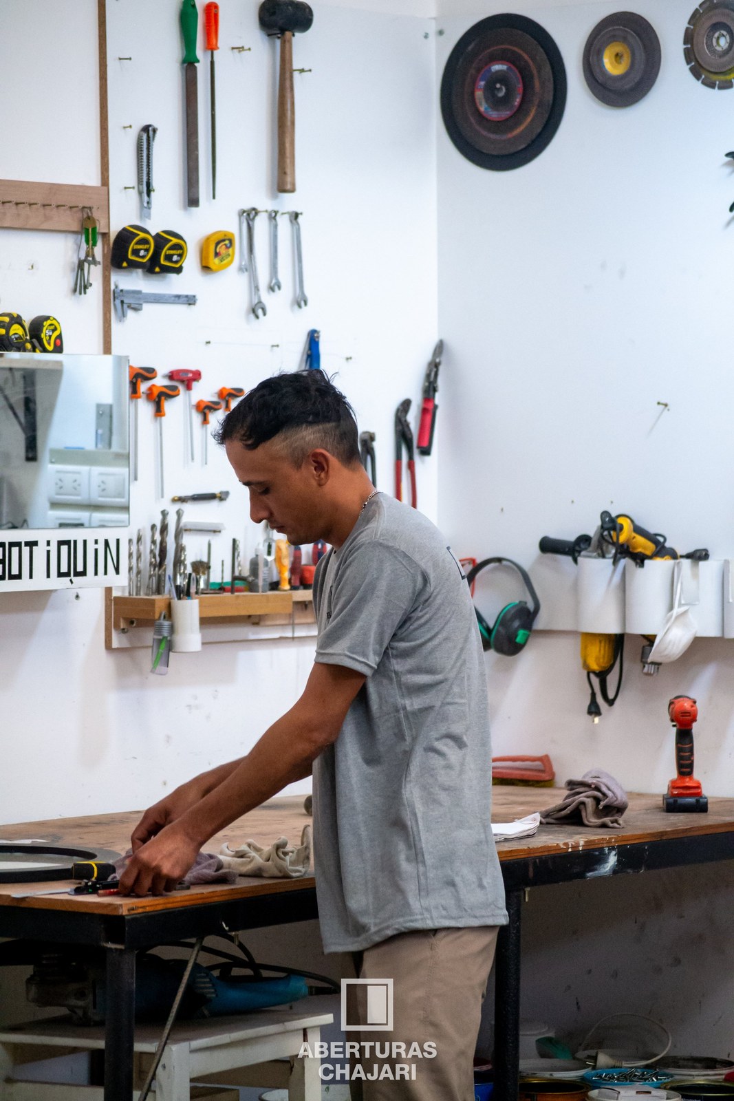 Interior del taller con perfiles de aluminio y máquinas de fabricación